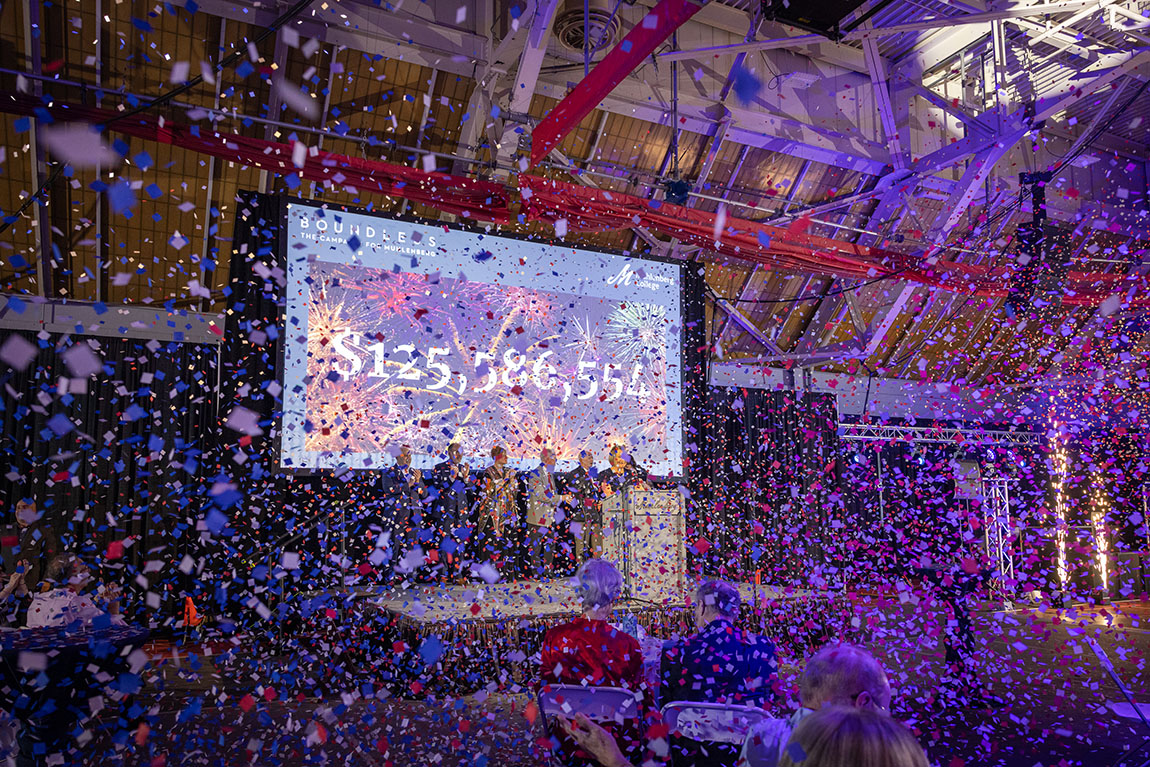 A view of the stage at a gala that's barely visible due to all the confetti that is falling